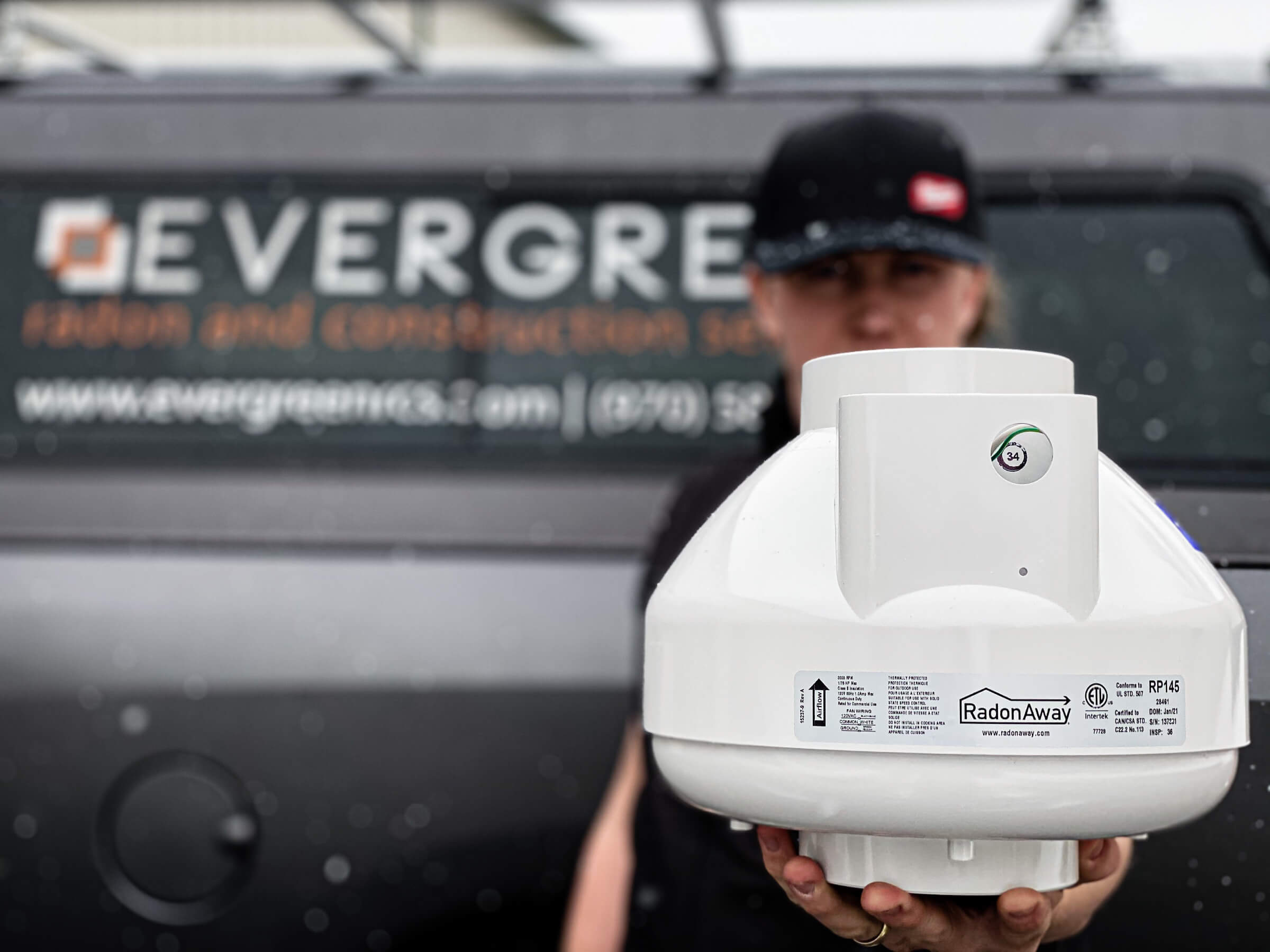 Radon mitigation system in technicians hand